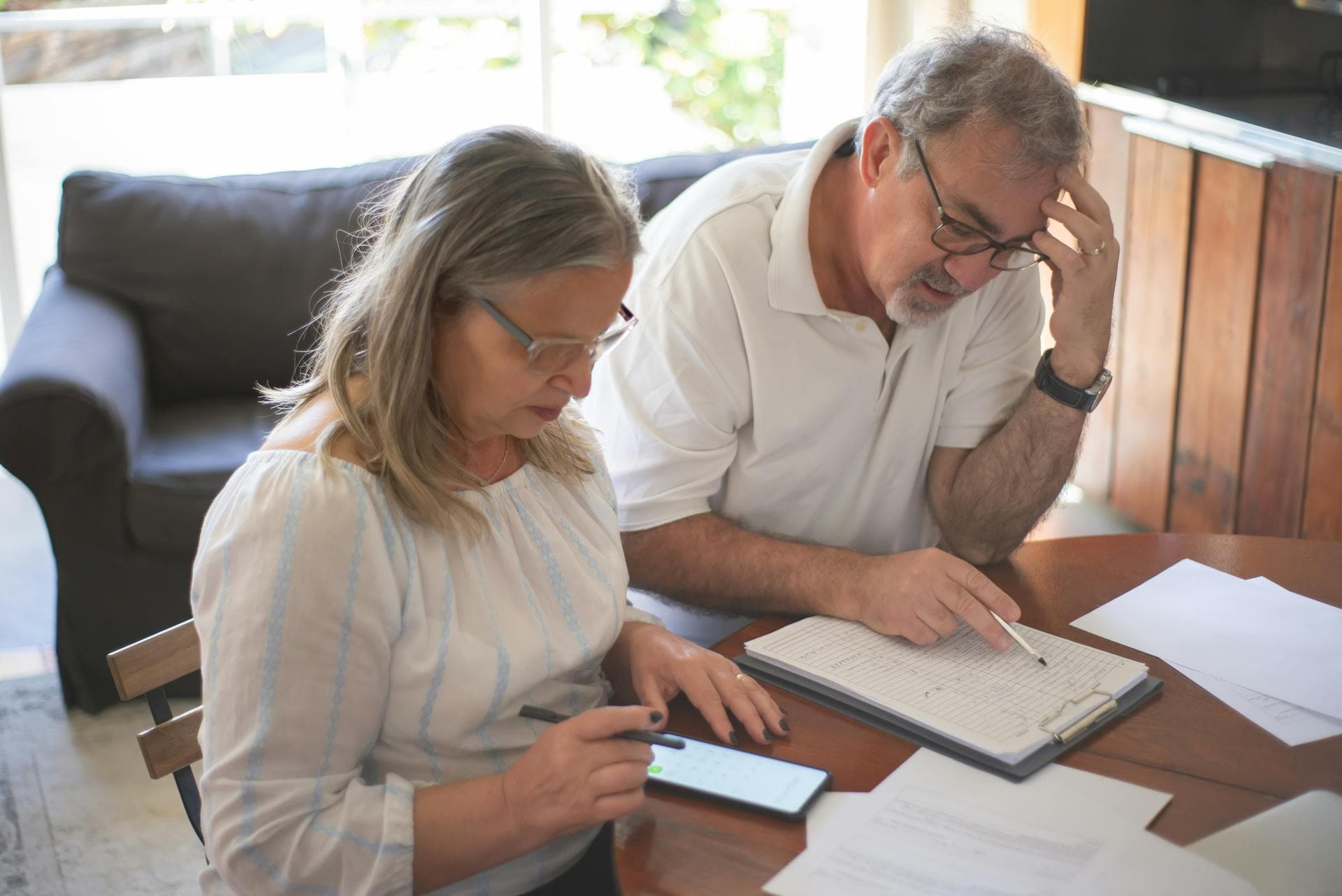 Senior couple reviewing bills and paperwork at their table